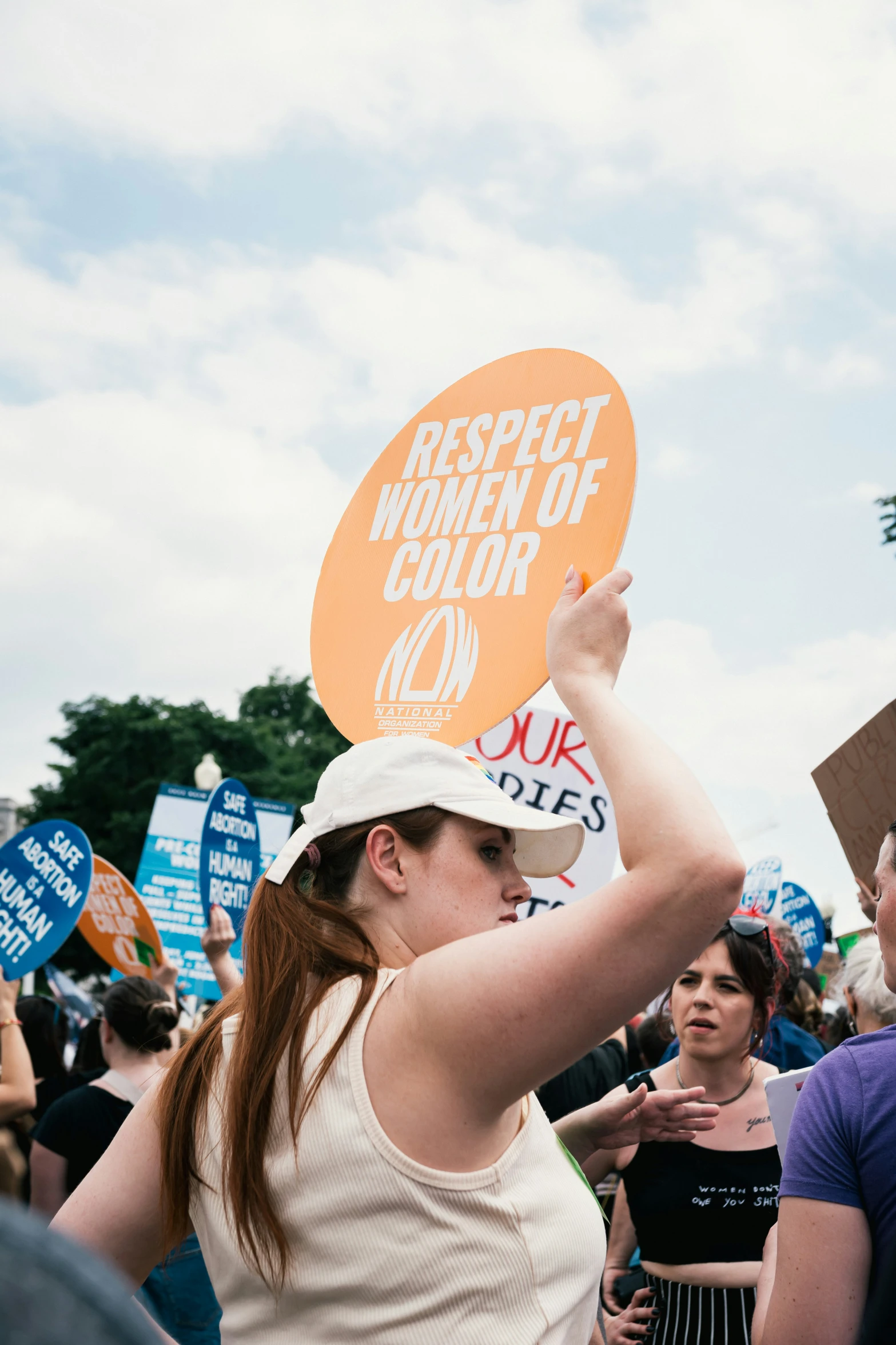 a woman holding a sign with an respect woman of color in it