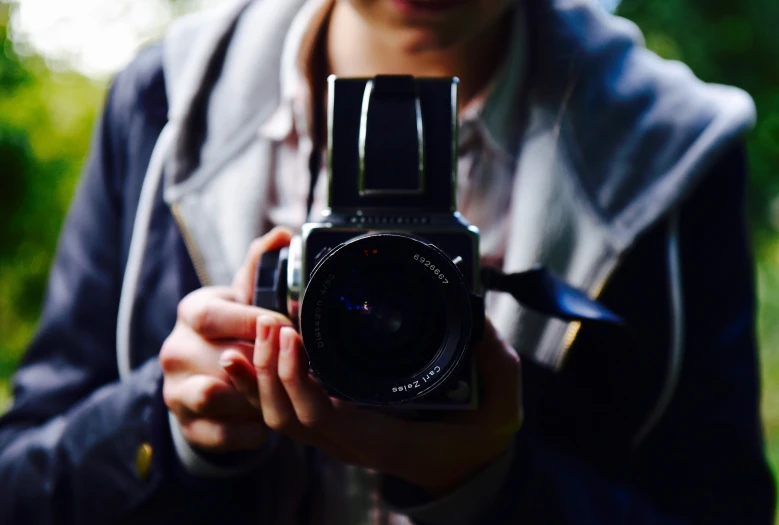 a person holding up a camera with a camera in their hand