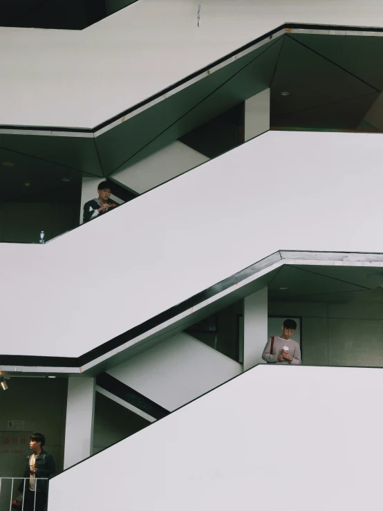 two men standing in balconies looking out from above