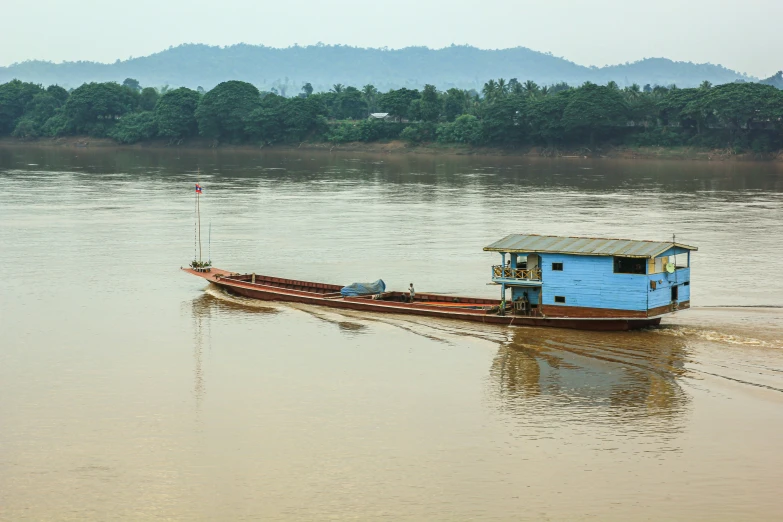 a small boat is on the water with trees in the background