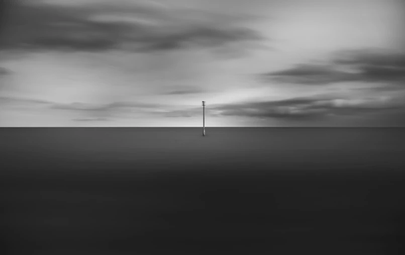 a lone pole is surrounded by dark, foggy skies