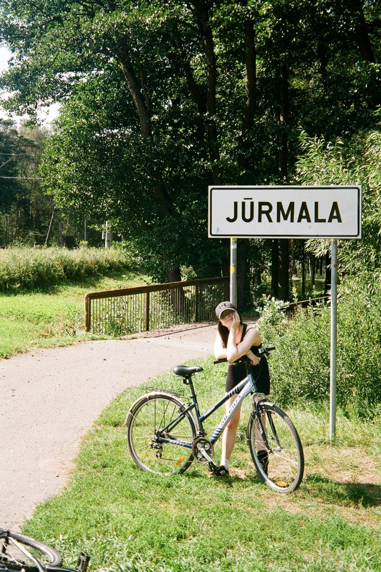 the person on the bicycle is taking a po near a sign