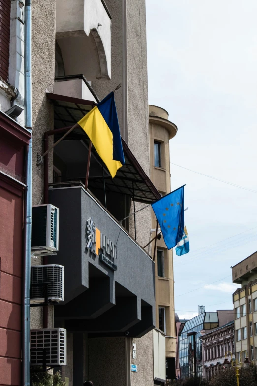 a large building has some flags on the roof