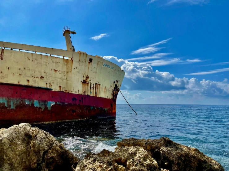 a red and white boat is docked on the shore