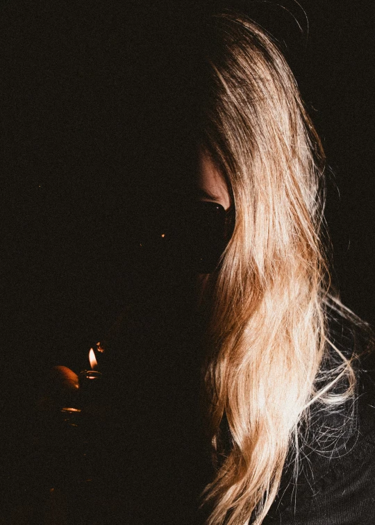 a woman with blond hair staring at the dark