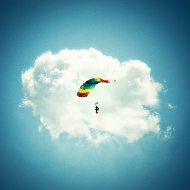 a person is in the air flying a colorful parachute