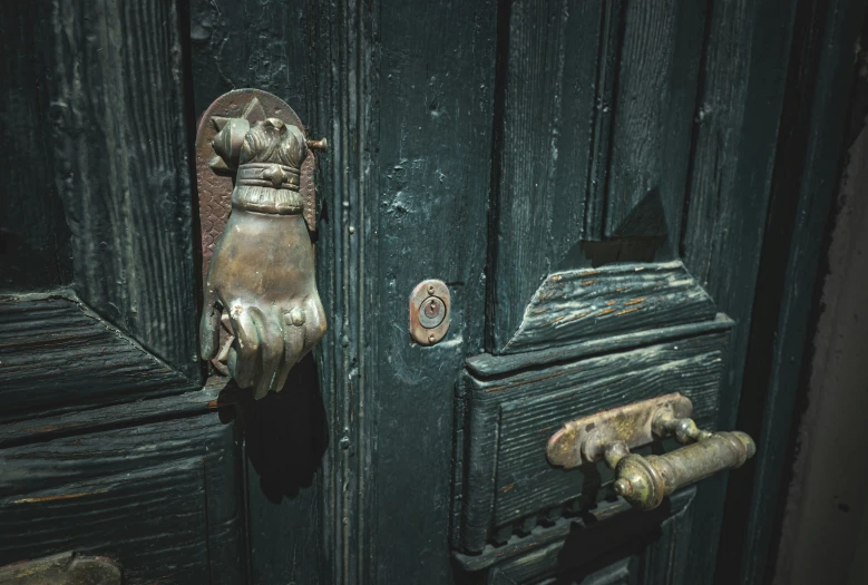 there is an old iron door that has a dirty glove hanging on it