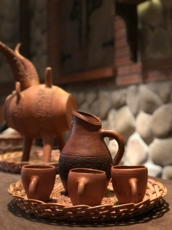 a table with brown cups and pitcher on top of it