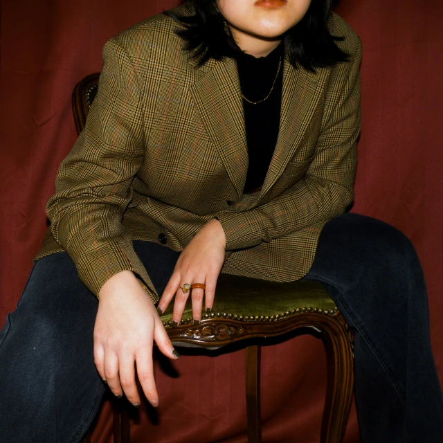 a young woman sitting on top of a wooden chair