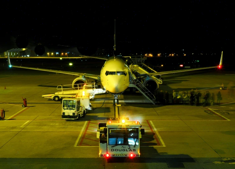 a truck and airport vehicles parked on an air port run way at night time