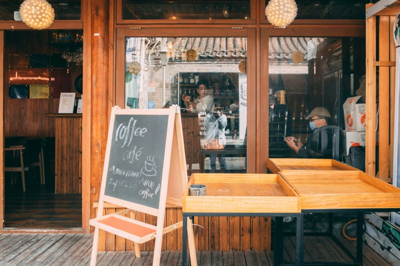 the restaurant is empty and has a chalk board sign in front of it