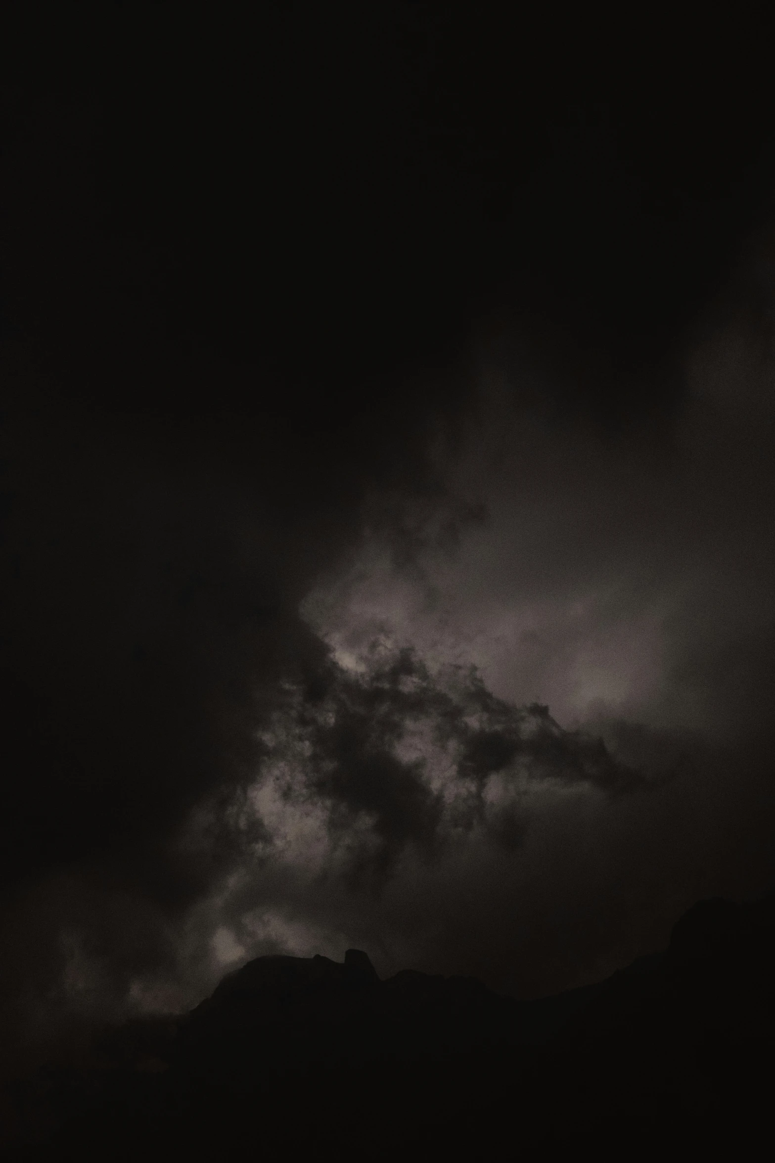 a plane flying high above the sky on a dark day