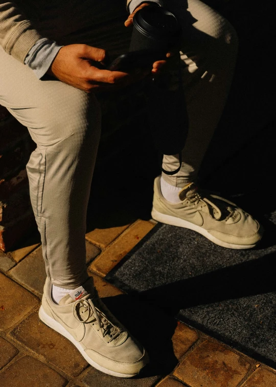 man is holding a bottle and standing on his skateboard