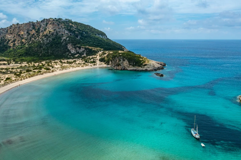 an empty boat is on the water near some sand and mountains