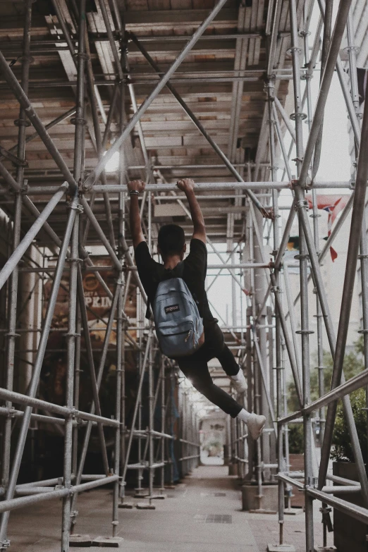 a man climbing on scaffolding in an urban setting