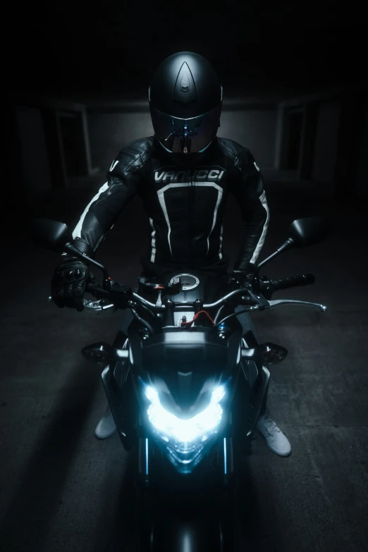 person sitting on motorcycle with head light glowing