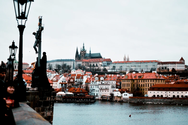 a man walking over a bridge looking down at the city