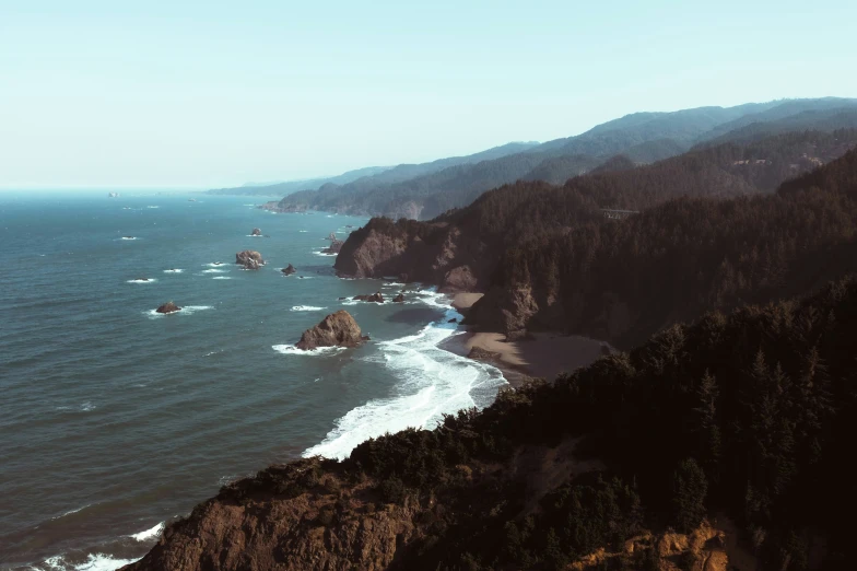 a beach next to large mountains and the ocean