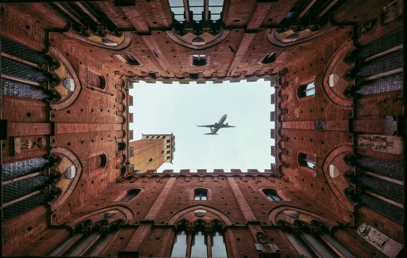 a plane flying in the sky between two buildings