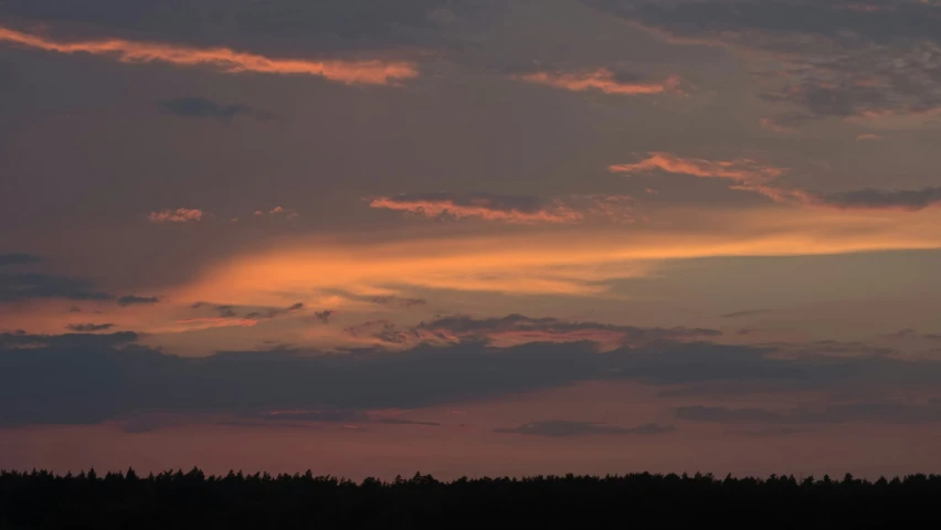 a po of an airplane flying in the sky at sunset