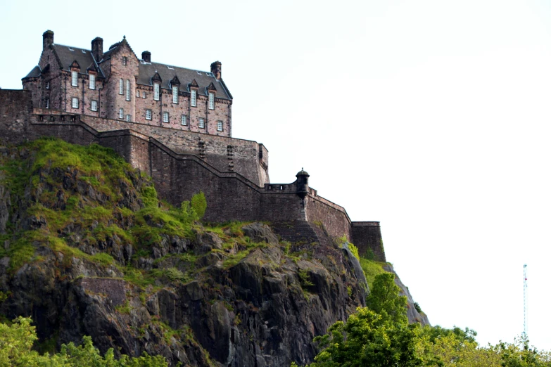 a castle on top of a mountain next to some trees