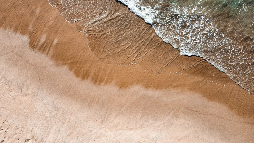 waves crash into the beach as they roll in