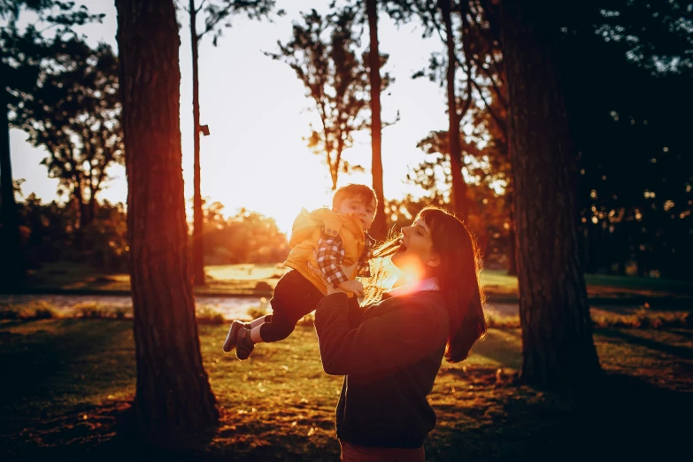 two women playing with a child in the park