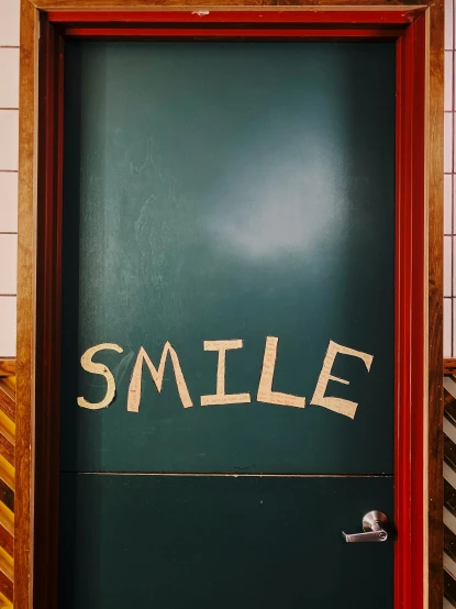 the door to a bathroom that says smile