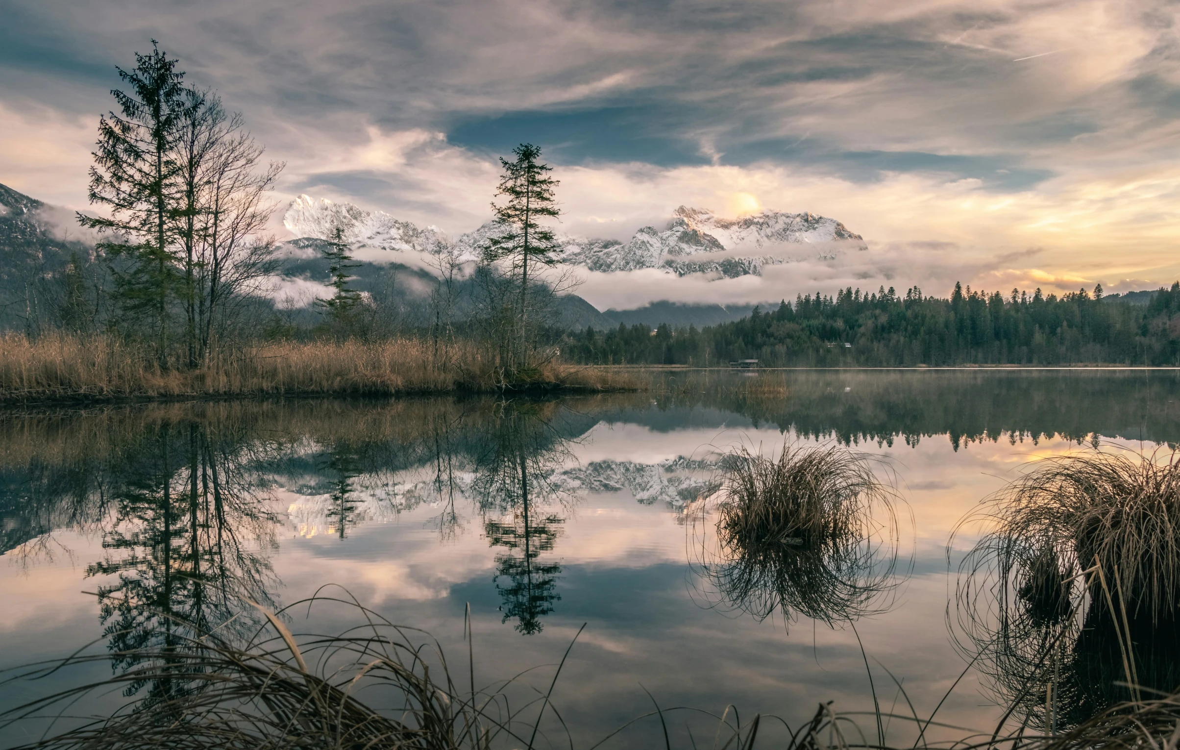 the water has a reflection of mountains in it