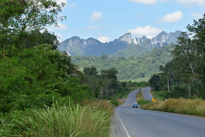 an empty road leading away towards the mountains