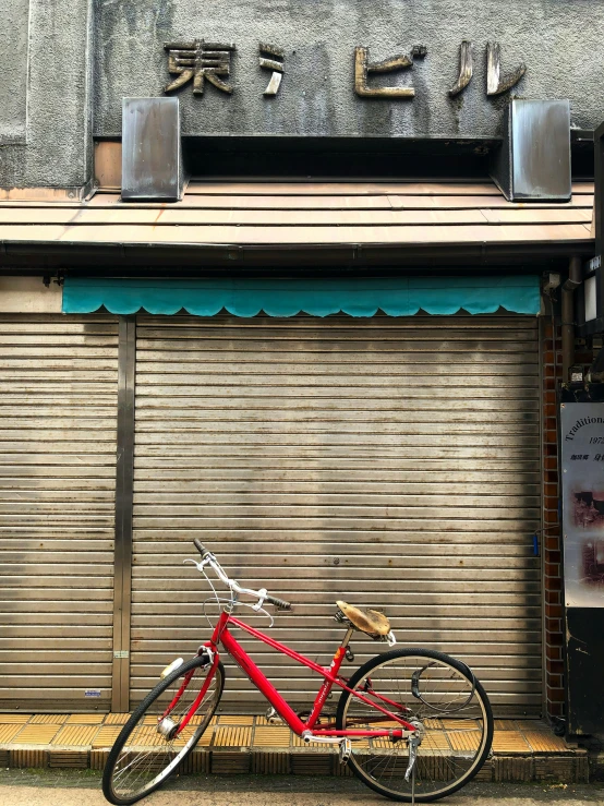 a red bike is parked next to a store