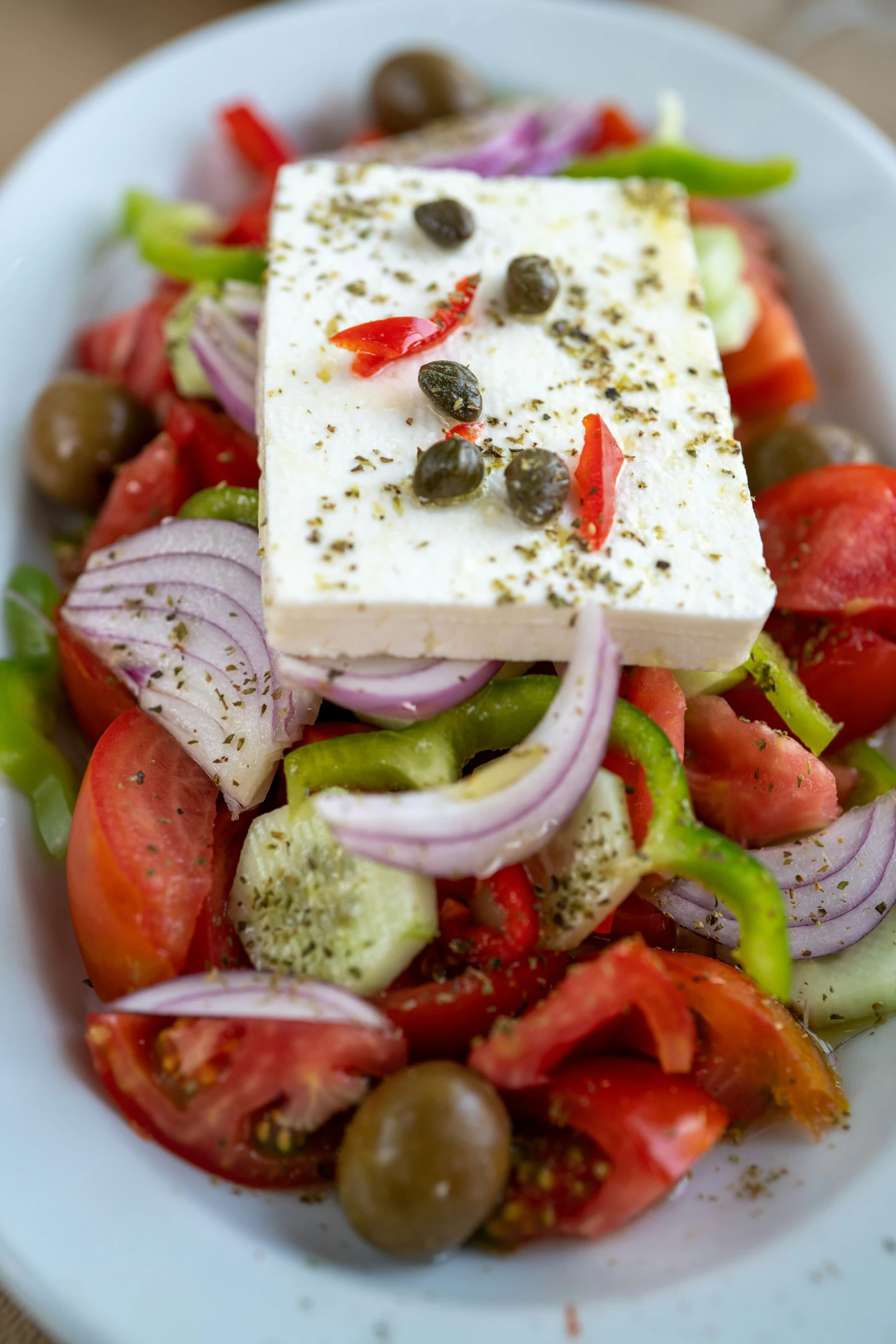 a white plate of vegetables with tofu on it