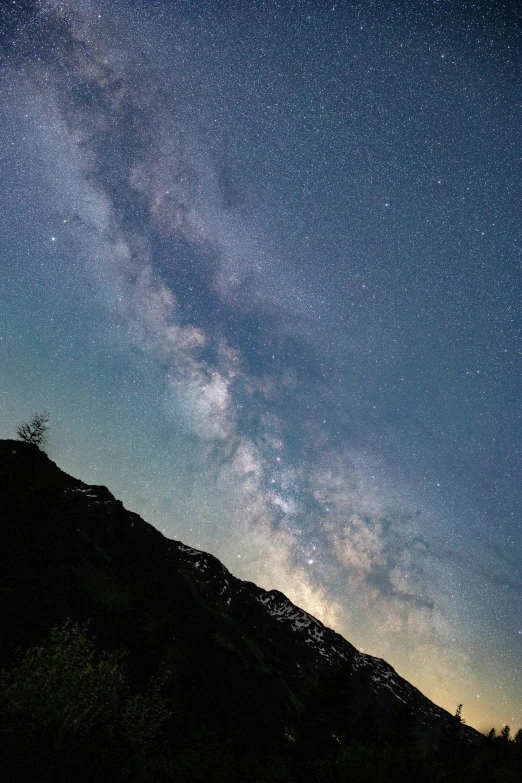 stars shine in the night sky over a mountain