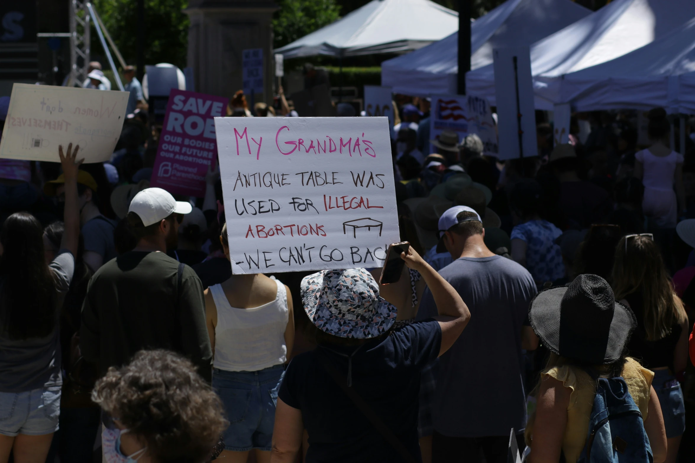 people protesting outside of a demonstration holding signs