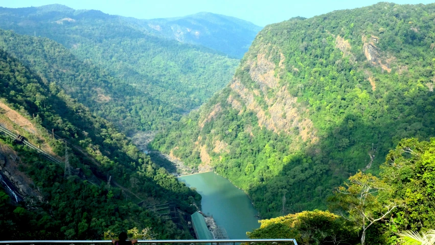 a bench overlooks an expansive river in the mountains