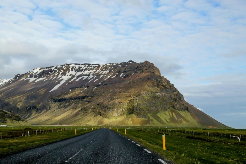 an empty road stretches out into a mountainous area