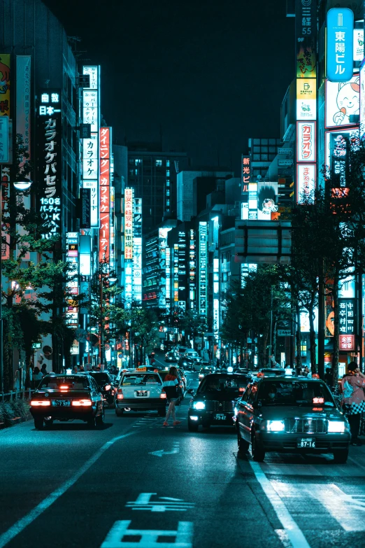 a city street with many cars in the middle at night