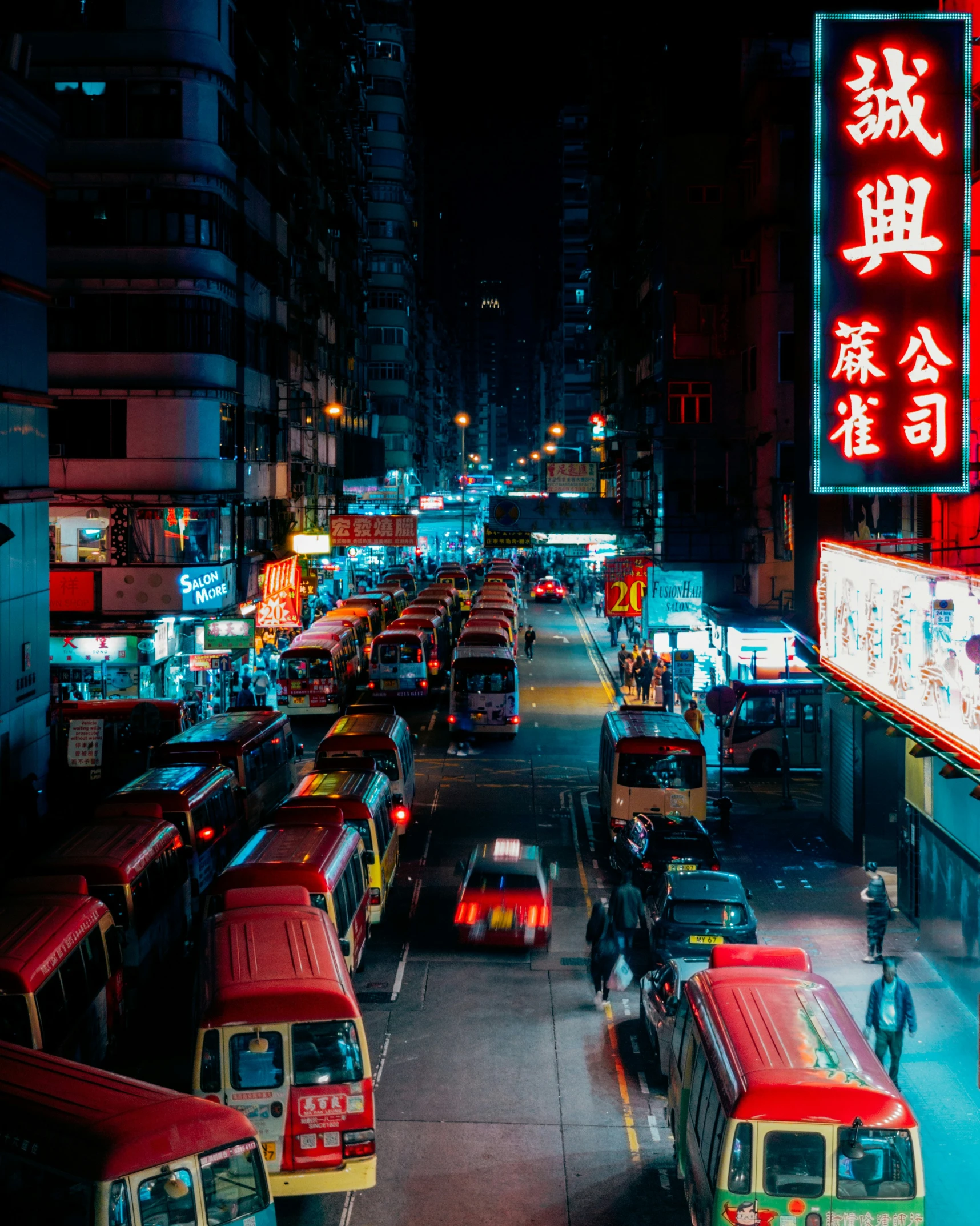 traffic drives along a busy street at night