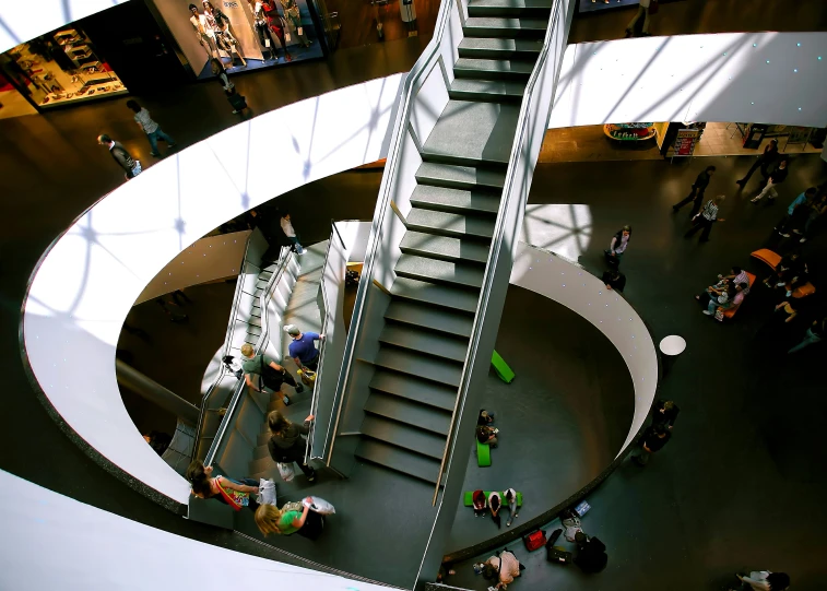 people on escalator in an indoor mall with skylights