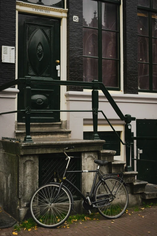 an old bike is leaning on the ledge next to a door