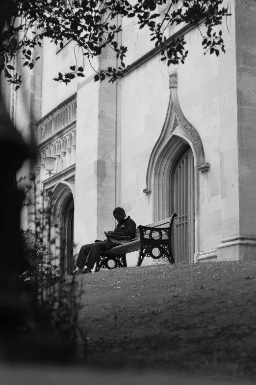 a black and white image of a person sitting on a bench