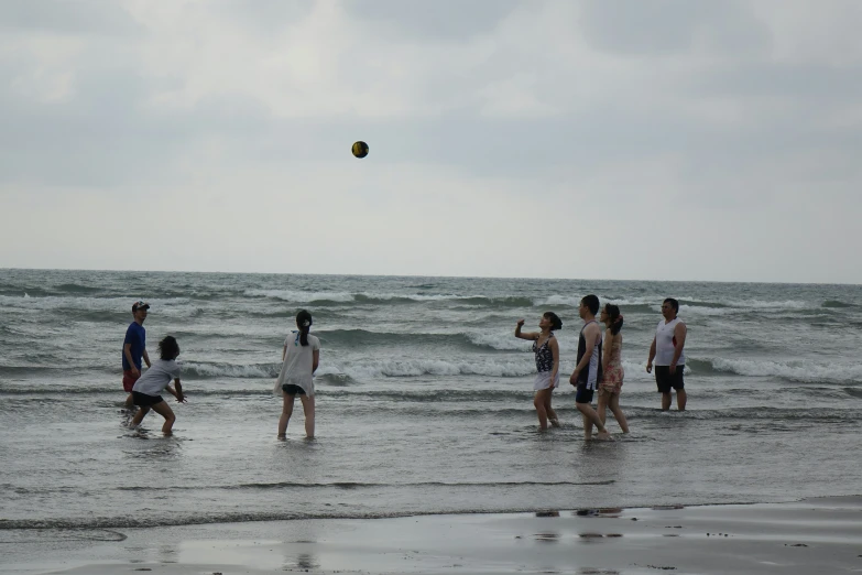 a group of people standing on top of the beach