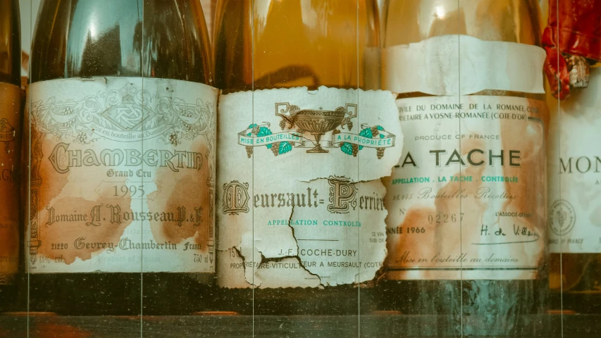 an assortment of old wine bottles in a cabinet