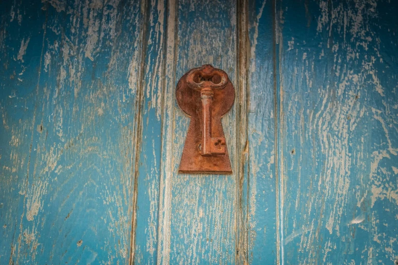 a vintage door with a brown handle is on the blue wooden wall