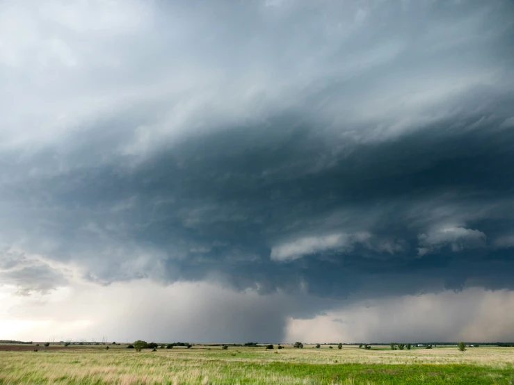 a big cloud is in the sky above a large field