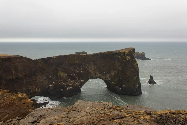 a rock formation surrounded by the ocean