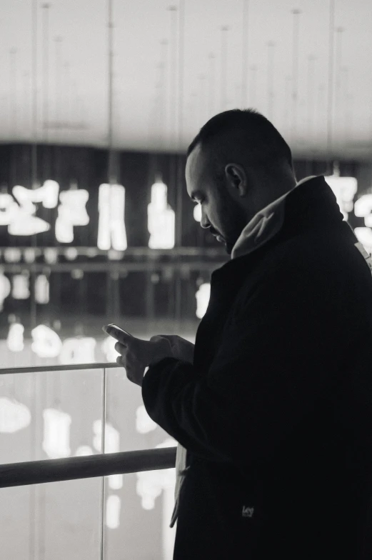 a man looking at his cell phone in an airport terminal