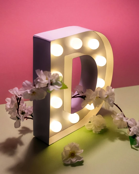 light up letters are decorated with flowers on the table