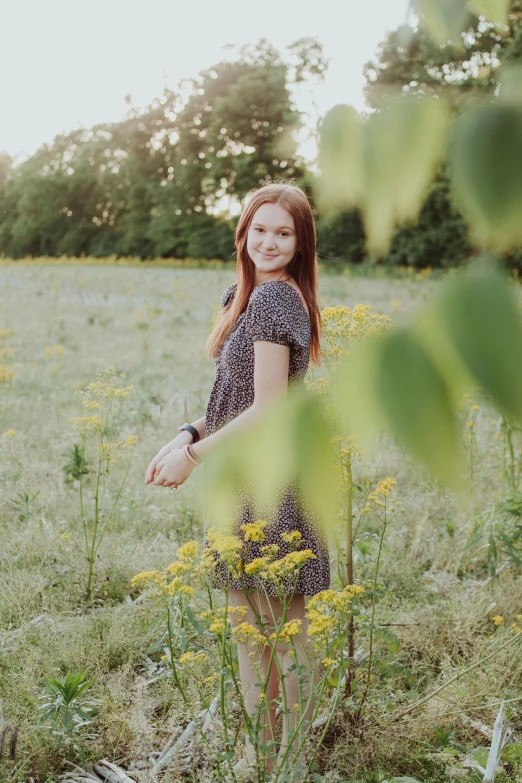 woman standing in a field with yellow wild flowers