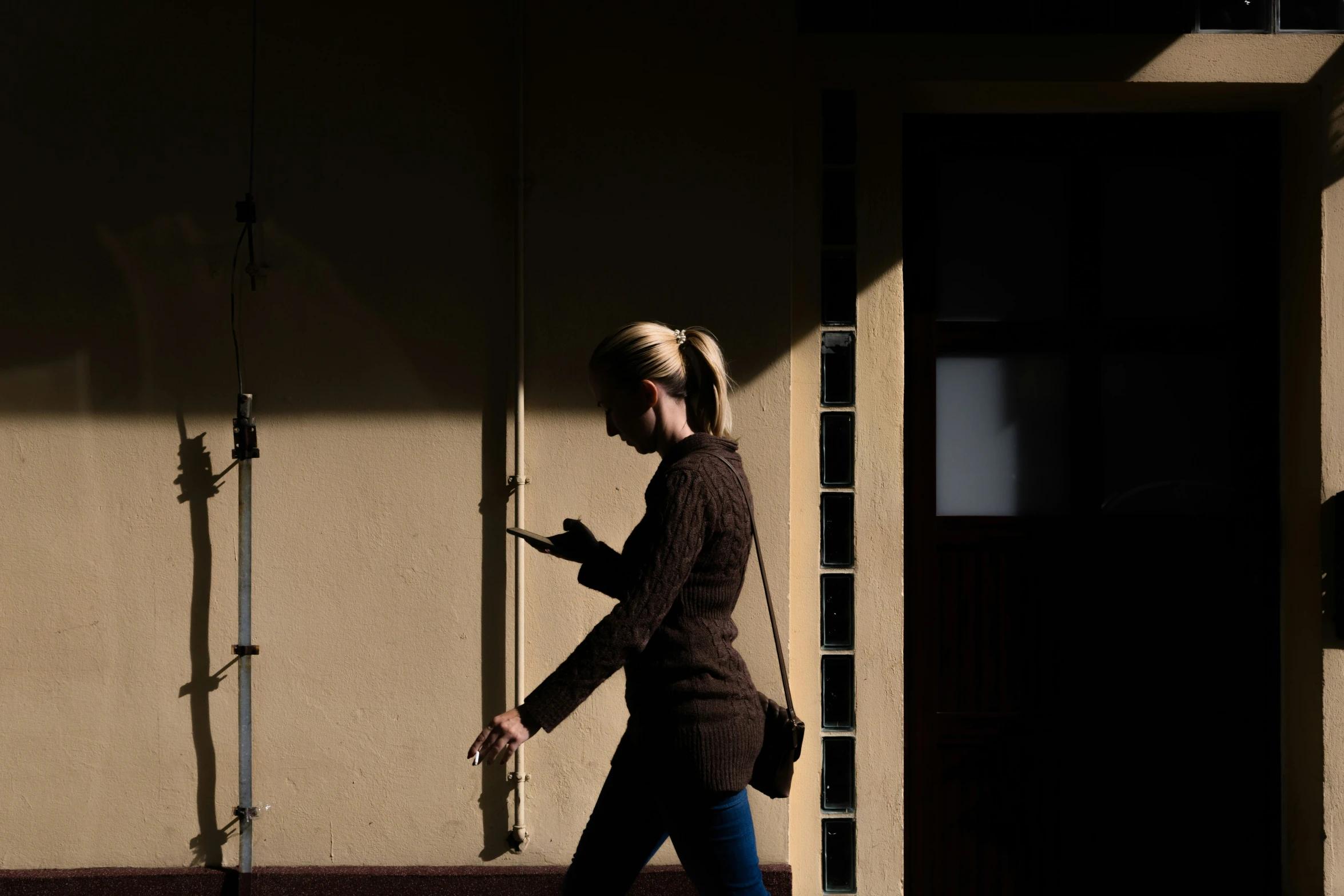 a woman walking down the street in dark shadows